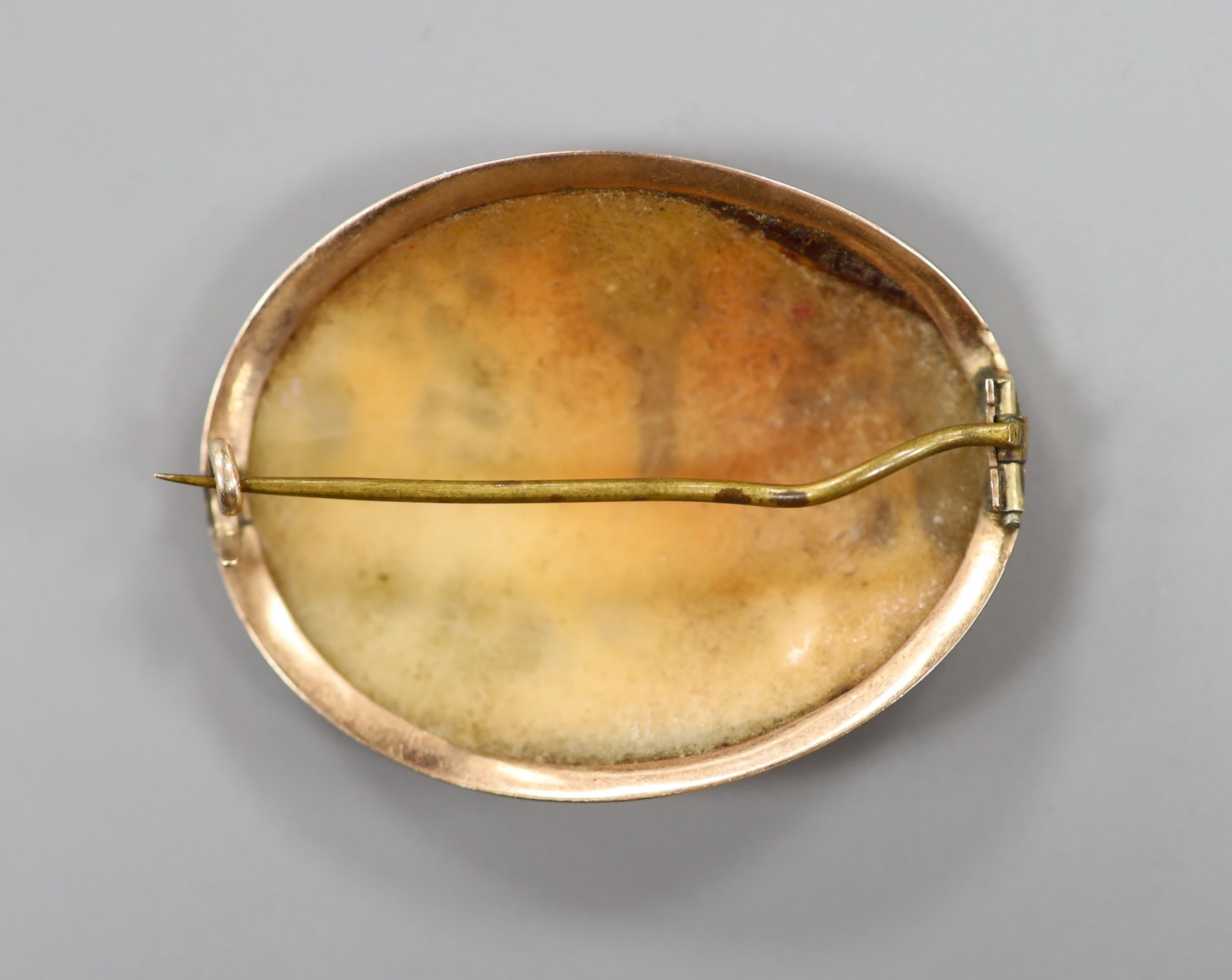 A yellow metal mounted antique oval cameo shell brooch, carved with classical figures, 4cm.